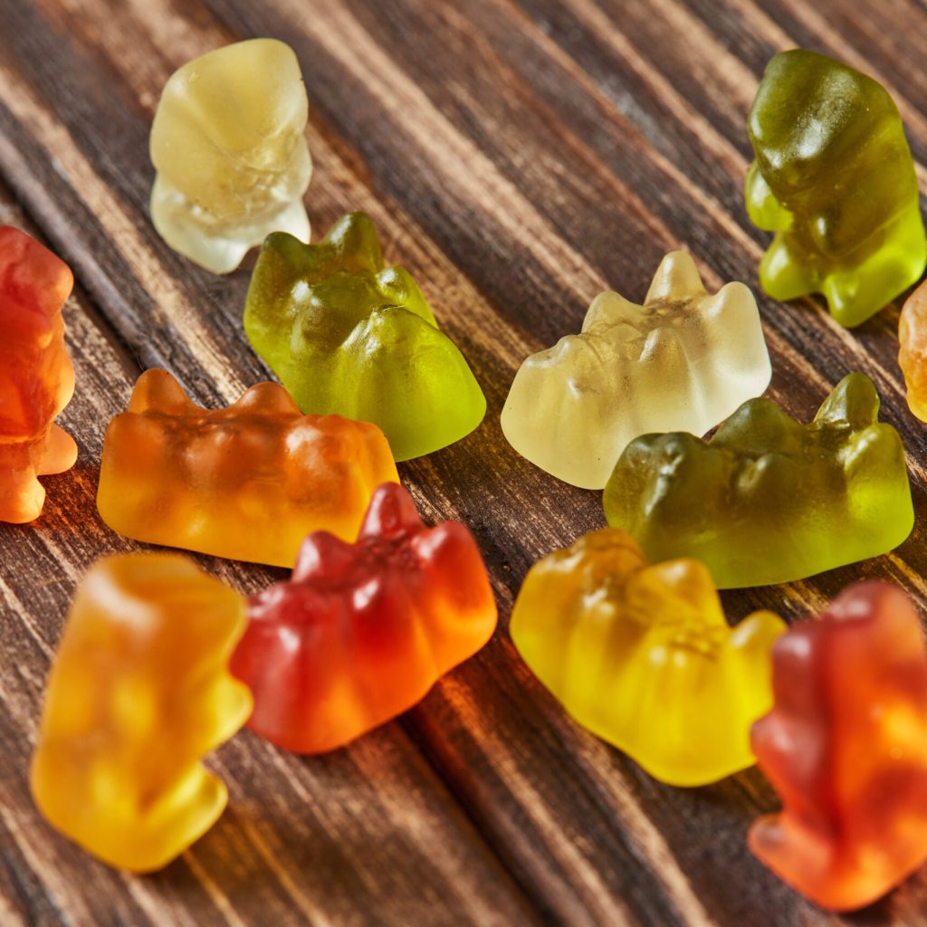 Multicolored bears gummy candy on wooden vintage background. Jelly candies of different colors.